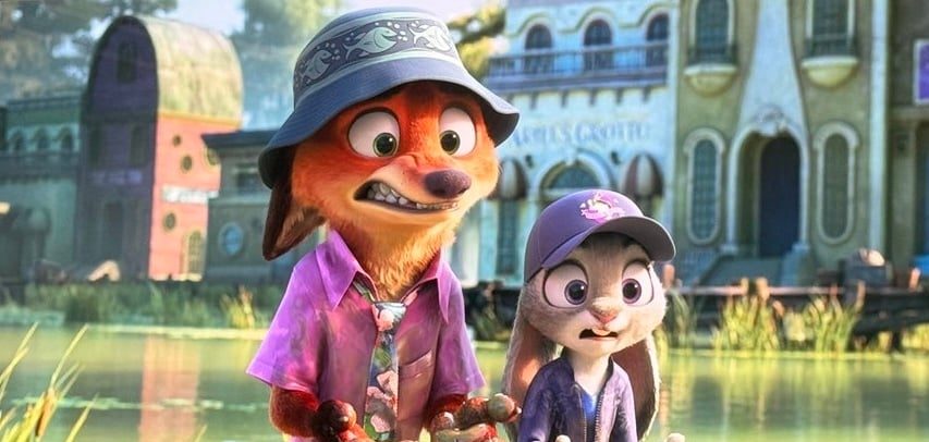 Nick Wilde e Judy Hopps di "Zootropolis 2" sono ritratti in piedi di fronte a uno sfondo scenografico lungo il fiume, caratterizzato da edifici colorati con finestre ad arco e vegetazione incolta. Entrambi i personaggi hanno un'espressione scioccata e angosciata mentre tendono le mani, che sono ricoperte da una sostanza non identificata. Nick è vestito con una camicia casual a fiori e un cappello a secchiello, mentre Judy indossa un cappellino da baseball e una giacca casual. La scena suggerisce un momento umoristico o sorprendente nel loro viaggio investigativo.